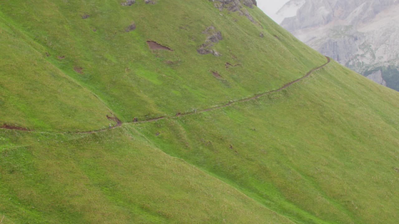grupo de personas excursionistas en la lejanía caminando por un sendero en las colinas de los dolomitas italianos alpes italia