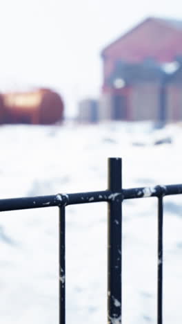una valla de metal negro frente a un patio nevado