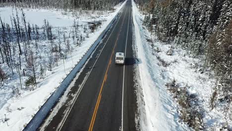 furgoneta conduciendo a través del frío y soleado cielo azul día de invierno en la campiña del norte de canadá - drone 4k antena