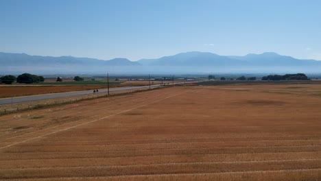 Vista-Aérea-De-Motocicletas-Conduciendo-Por-Una-Carretera-Hacia-Las-Montañas.