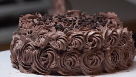 Pastel-De-Chocolate-En-La-Mesa-Giratoria-Con-Glaseado-De-Diseño-Floral