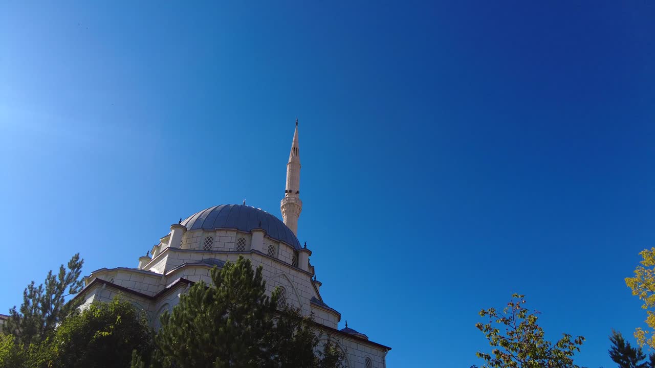 una mezquita con un cielo azul y un solo minarete, una mezquita de barrio en turquía,