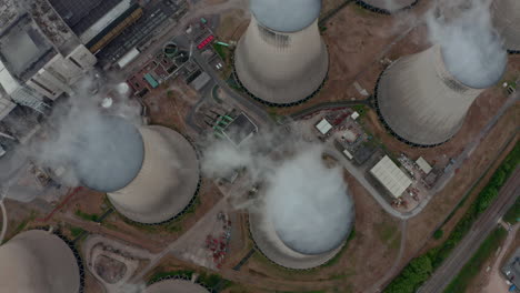 pan up revealing drone shot of large power plant cooling towers