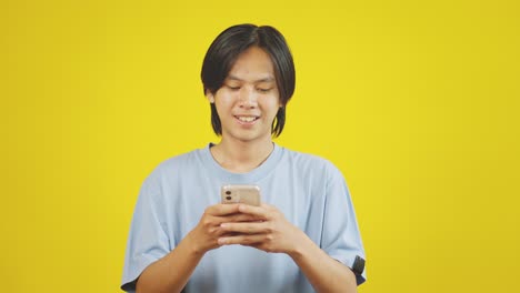 Young-Asian-Man-Using-Mobile-Phone-And-Showing-The-Screen-At-Camera