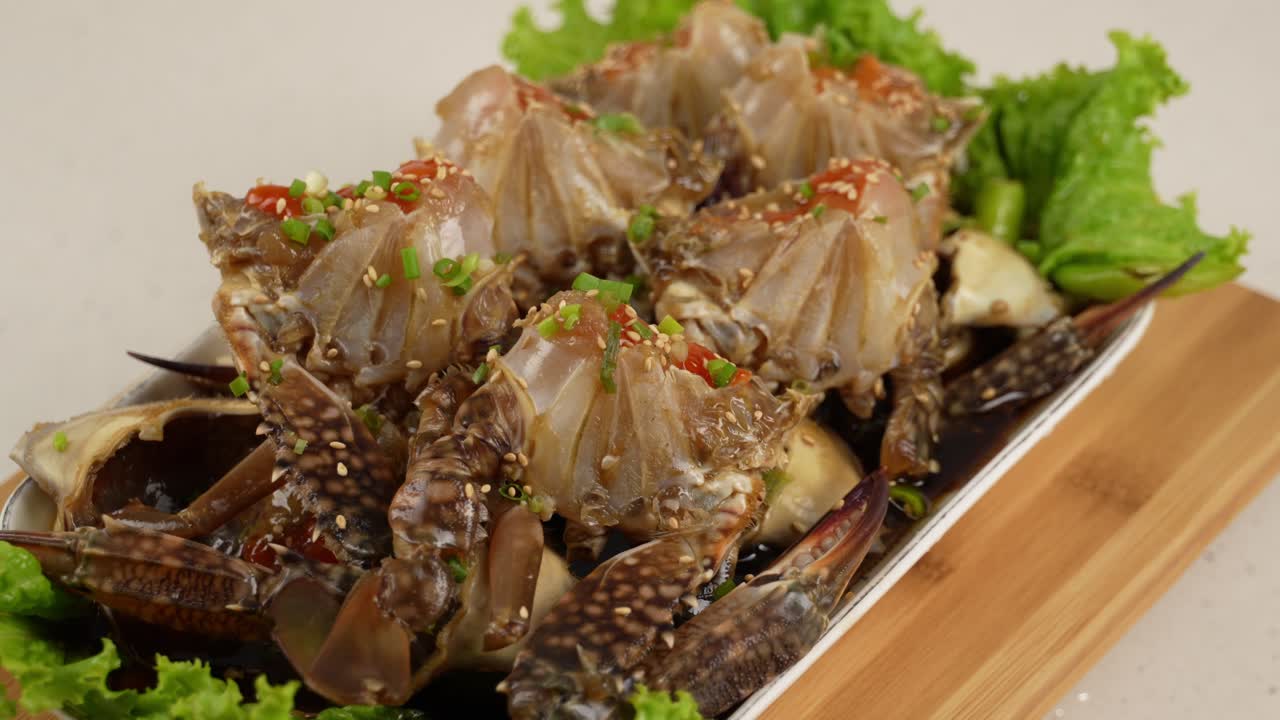 Fresh raw crab marinated in soy sauce, enriched with sesame and chili for a savory depth. 신선한 꽃게를 간장에 숙성시켜 감칠맛과 풍미가 살아있는 한 접시.