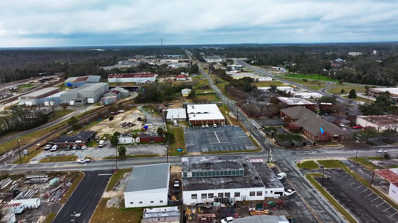 Aerial flyover industrial district of Valdosta with destroyed Buildings and railway tracks. Cloudy day in suburb of american town in Georgia. Wide shot.