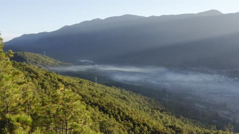 Deforestation-burning-smoke-in-China-mountain-valley,-agriculture-impact,-aerial