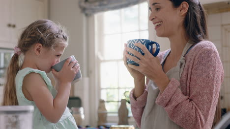 mother and daughter drinking hot chocolate together in kitchen happy mom caring for little girl enjoying homemade delicious beverage at home