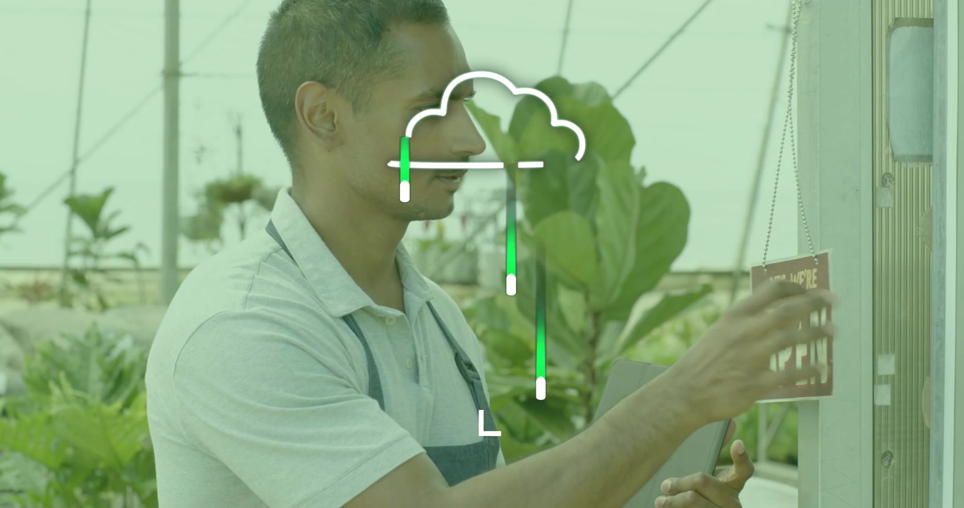 Viveirista andando pelo corredor da estufa escaneando plantas com tablet e virando a placa de "aberto"
