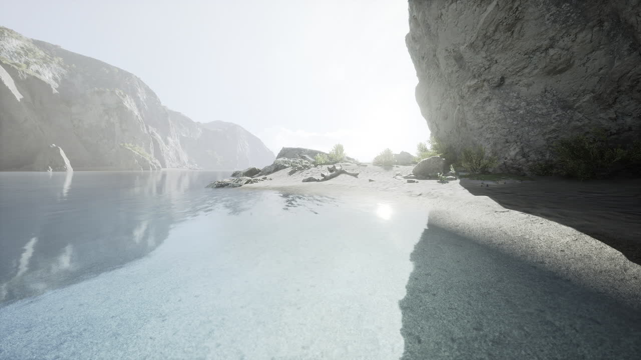 спокойный пляжный пейзаж с мягкими волнами и освещенными солнцем горами