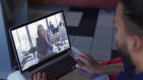 Afroamerikanischer-Mann,-Der-Zu-Hause-Einen-Videoanruf-Mit-Einer-Bürokollegin-Auf-Dem-Laptop-Führt