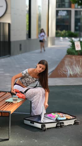 mujer empacando la maleta al aire libre
