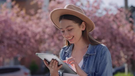 young woman using tablet in springtime city