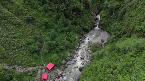 serene aerial view of a flowing water stream in lush green landscape 4k drone footage