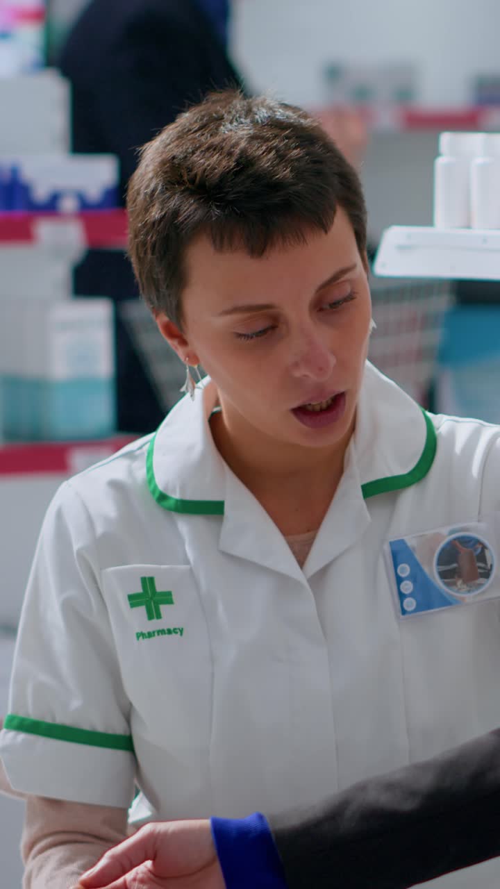 Vídeo vertical de farmacéutico usando un medidor de presión arterial