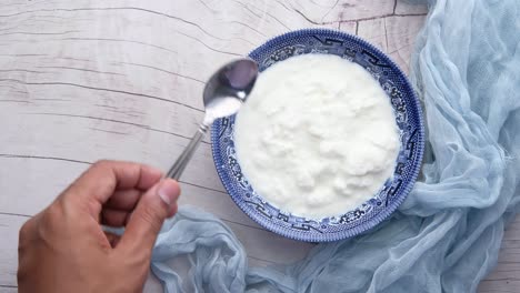yogur en un tazón con cuchara y paño