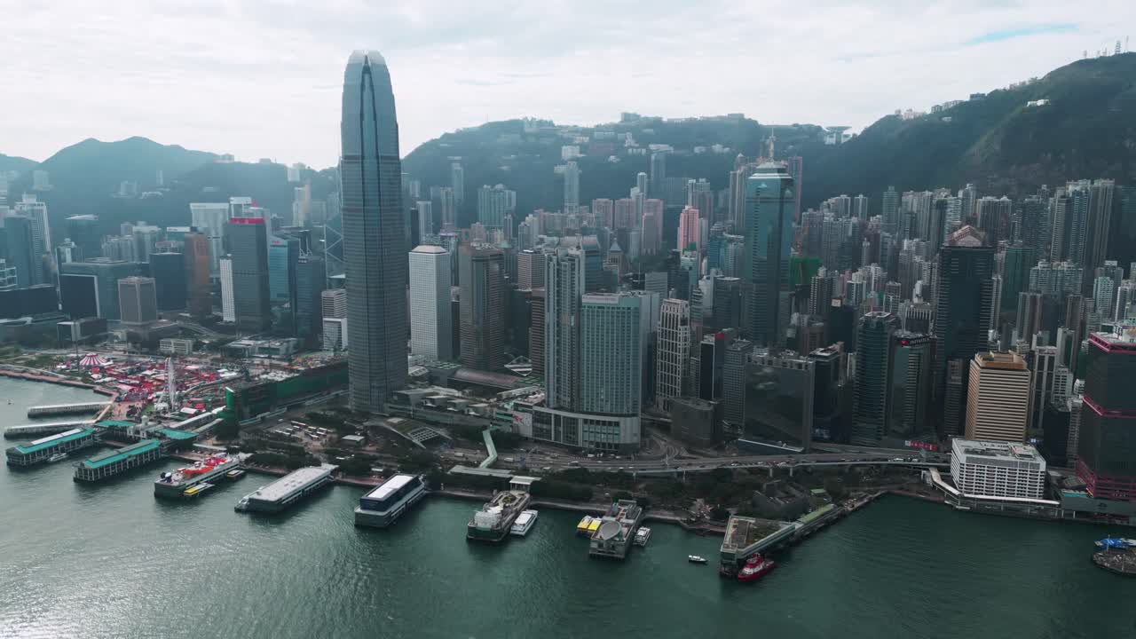 Pemandangan udara panorama gedung pencakar langit dan Pelabuhan Victoria di pusat kota Hong Kong pada hari yang cerah, menampilkan garis langit dan tepi laut yang ikonik