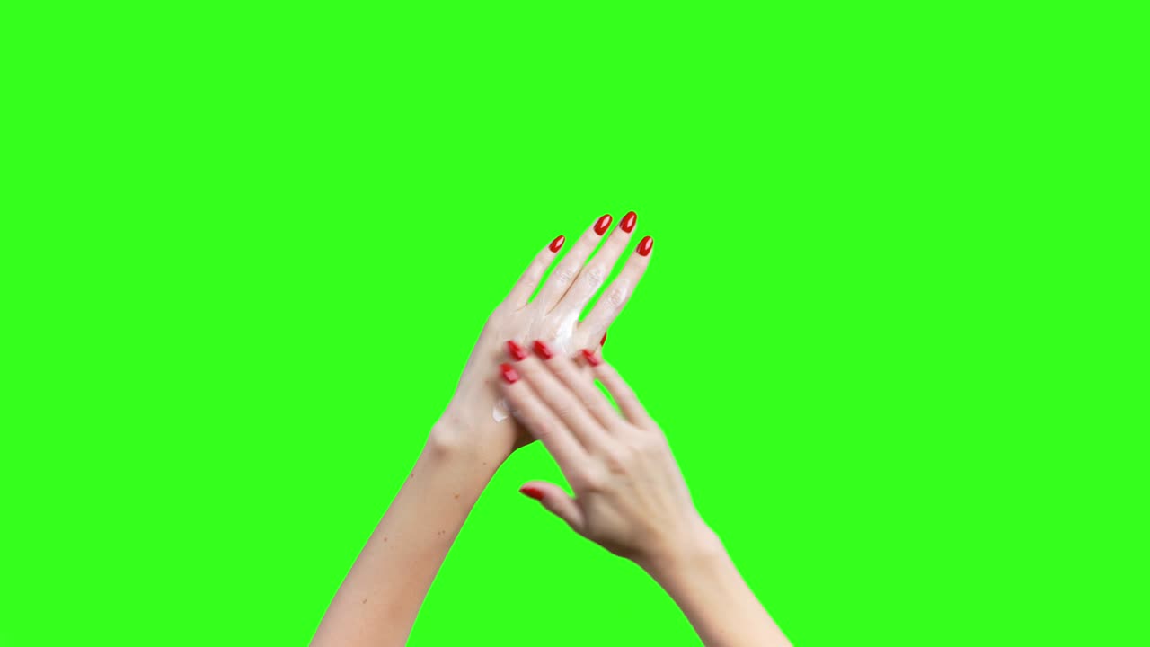 video de manos femeninas untando crema sobre un fondo verde