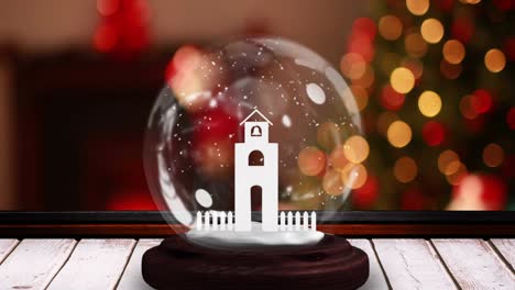 animación de globo de nieve con torre de iglesia en superficie de madera sobre luces de hadas parpadeantes