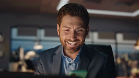 closeup man answering call at night corporate office. director talking phone