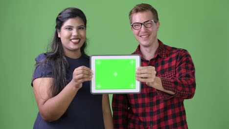 joven pareja de negocios multiétnica juntos contra un fondo verde