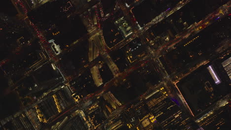 Aerial-birds-eye-overhead-top-down-view-of-heavy-traffic-in-streets-of-night-city.-Fly-above-borough-with-regular-grid-of-streets.-Manhattan,-New-York-City,-USA