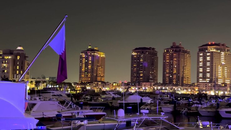 Bandiera del Qatar su un grande yacht costoso nella laguna perla del Qanat Quartier, simile a Venezia, a Doha di notte