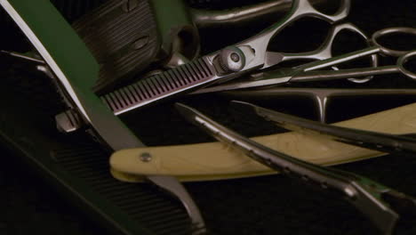 light reflects off chrome antique barber tools: ivory razor, shears