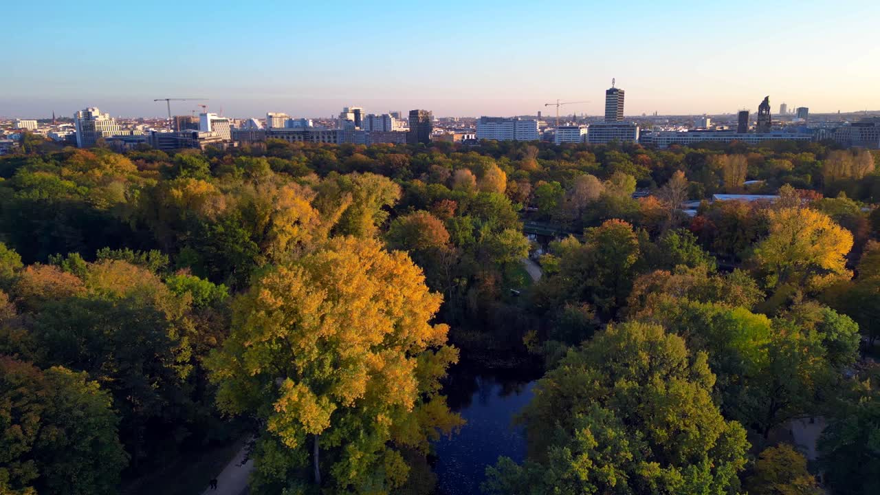 colorful autumn foliage in berlin's tiergarten park with the city skyline in the distance. Unbelievable aerial view flight overflight flyover drone