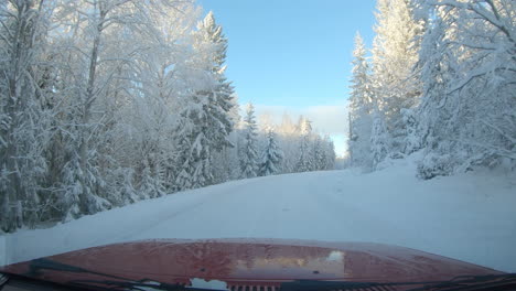 Windscreen-view-driving-along-a-snow-covered-road-in-Sweden