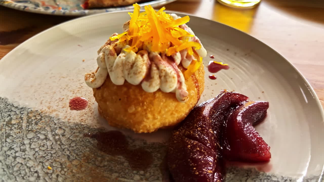 Bombolone fritto farcito con panna, noci pecan, scorza d'arancia e pere cotte