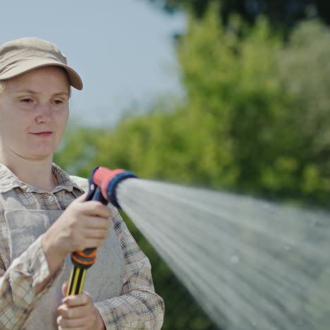 Gardener-sprays-water-from-a-garden-hose-3