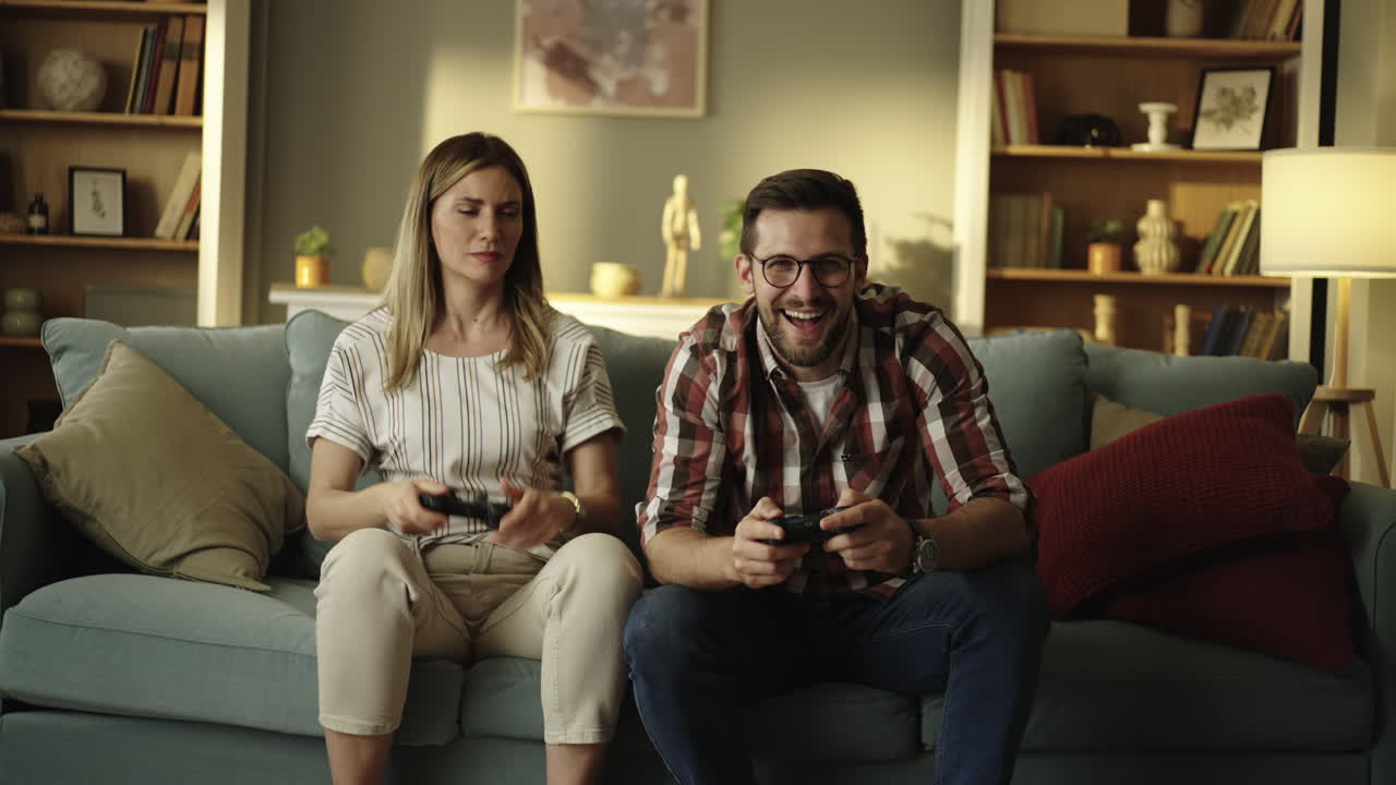 pareja jugando videojuegos en el sofá