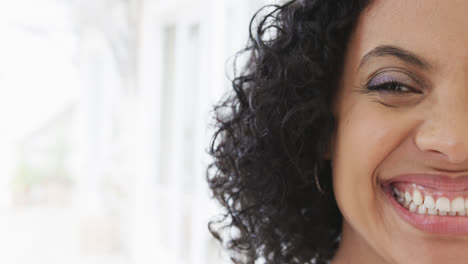 medio retrato de una mujer biracial feliz en casa con espacio de copia, cámara lenta