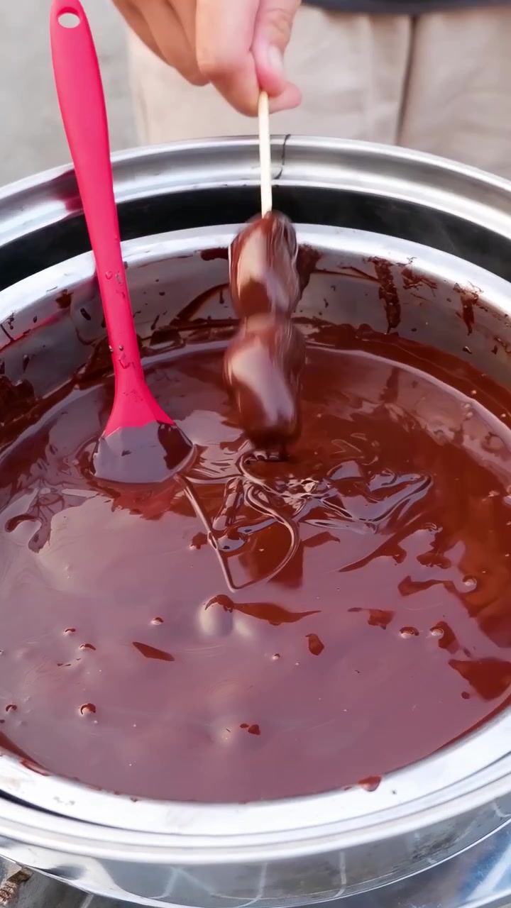 Intingere cibo nella fonduta di cioccolato