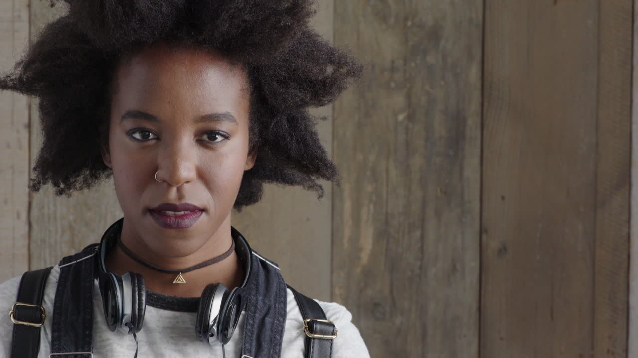 retrato de una joven afroamericana independiente que mira seriamente a la cámara con un peinado afro funky espacio de copia