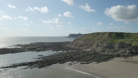 right-to-left-reveal,-Aerial-view-of-North-bay,-Scarborough,-North-Yorkshire-with-cliffs,-coastline,-ocean,-and-castle