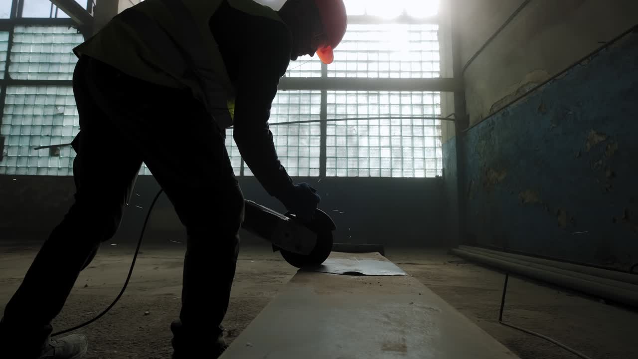 건설 노동자가 원형 도자기로 강철을 잘라내는 근접 영상, 건설 노동자의 발, 원형도자리에서 날아오는 불꽃.