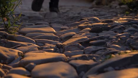 man walking on the cobblestones of an old street at sunset in slow motion in a provencal french village