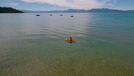 an aerial over a woman paddling a kayak across lake tahoe 5