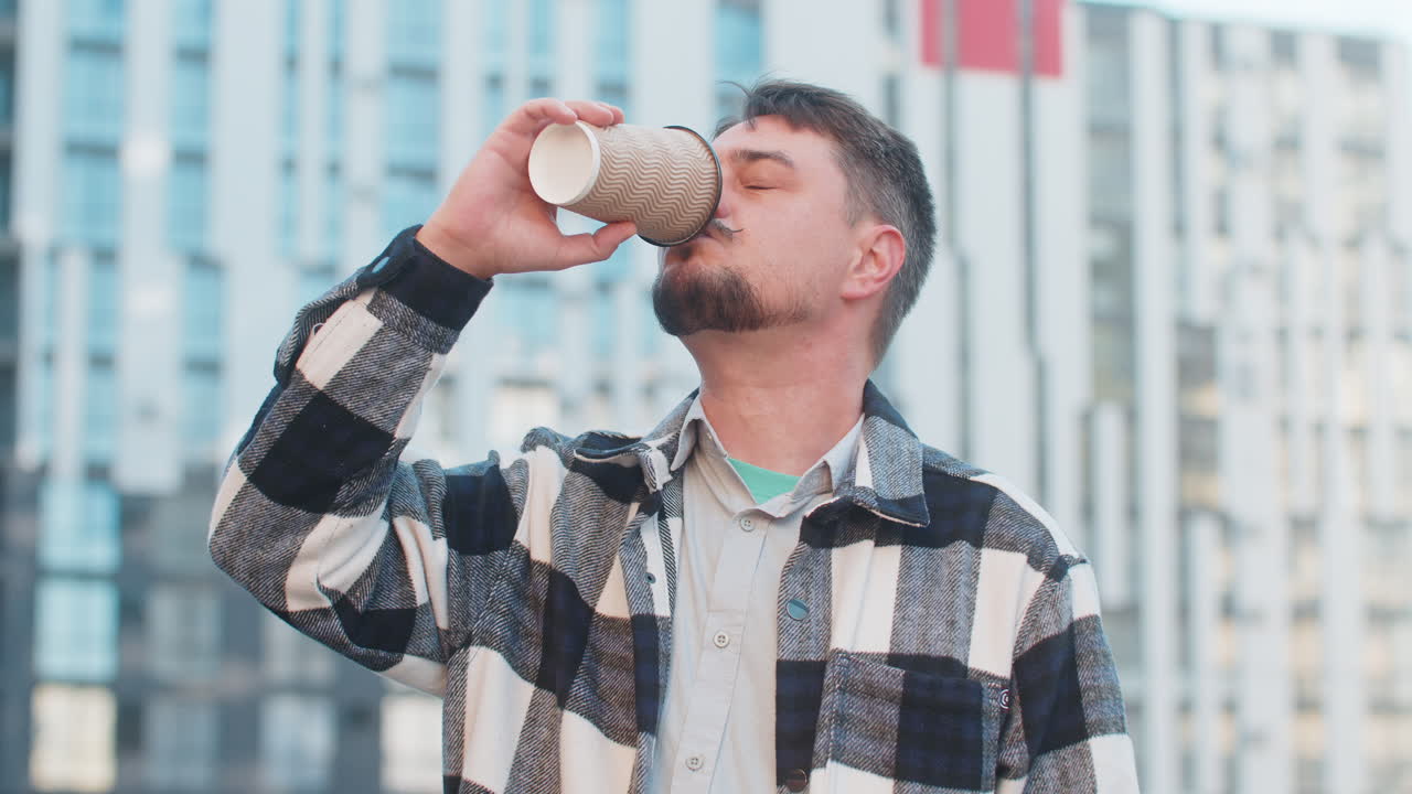 feliz hombre caucásico de mediana edad turista disfrutando del café de la mañana bebida caliente en la calle del centro de la ciudad