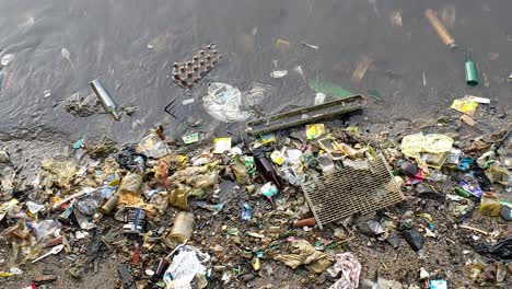 Washed-up-ocean-plastic,-trash-and-other-rubbish-pollution-along-the-shoreline-of-Sorong-in-West-Papua-province,-Indonesia