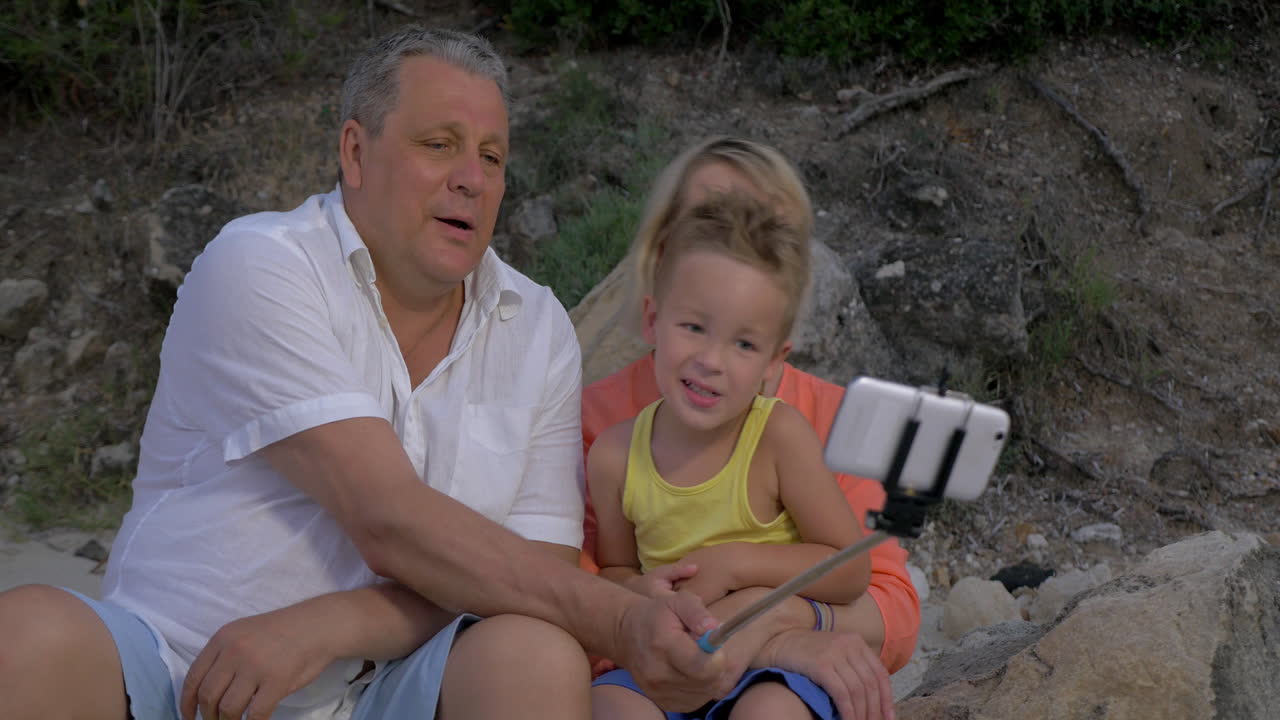 familia unida tomando una selfie con un bastón monopod
