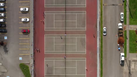 top view of people playing tennis on outdoor tennis courts on a sunny day