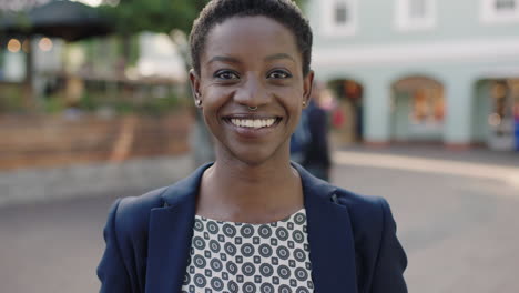 Retrato-En-Cámara-Lenta-De-Una-Hermosa-Mujer-De-Negocios-Afroamericana-Sonriendo-Alegre-Mirando-La-Cámara-Usando-Chaqueta-De-Traje-En-La-Ciudad