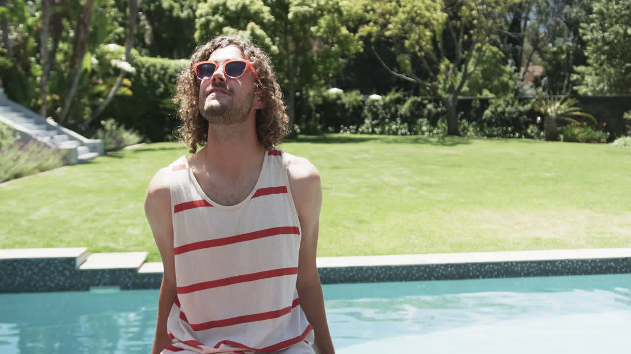 Junger kaukasischer Mann genießt die Sonne am Pool, mit Platz für Text.