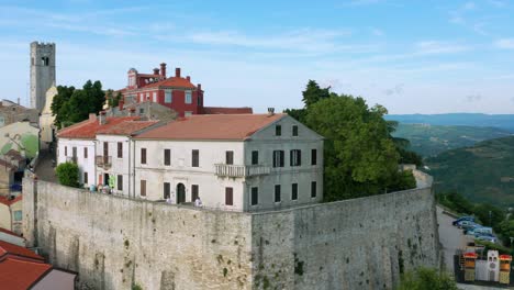 aerial shot circling around the walls of the old town of motovun, croatia on a bright afternoon