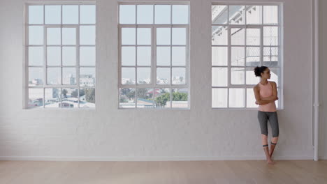 beautiful young mixed race woman in yoga class waiting arms crossed copy space