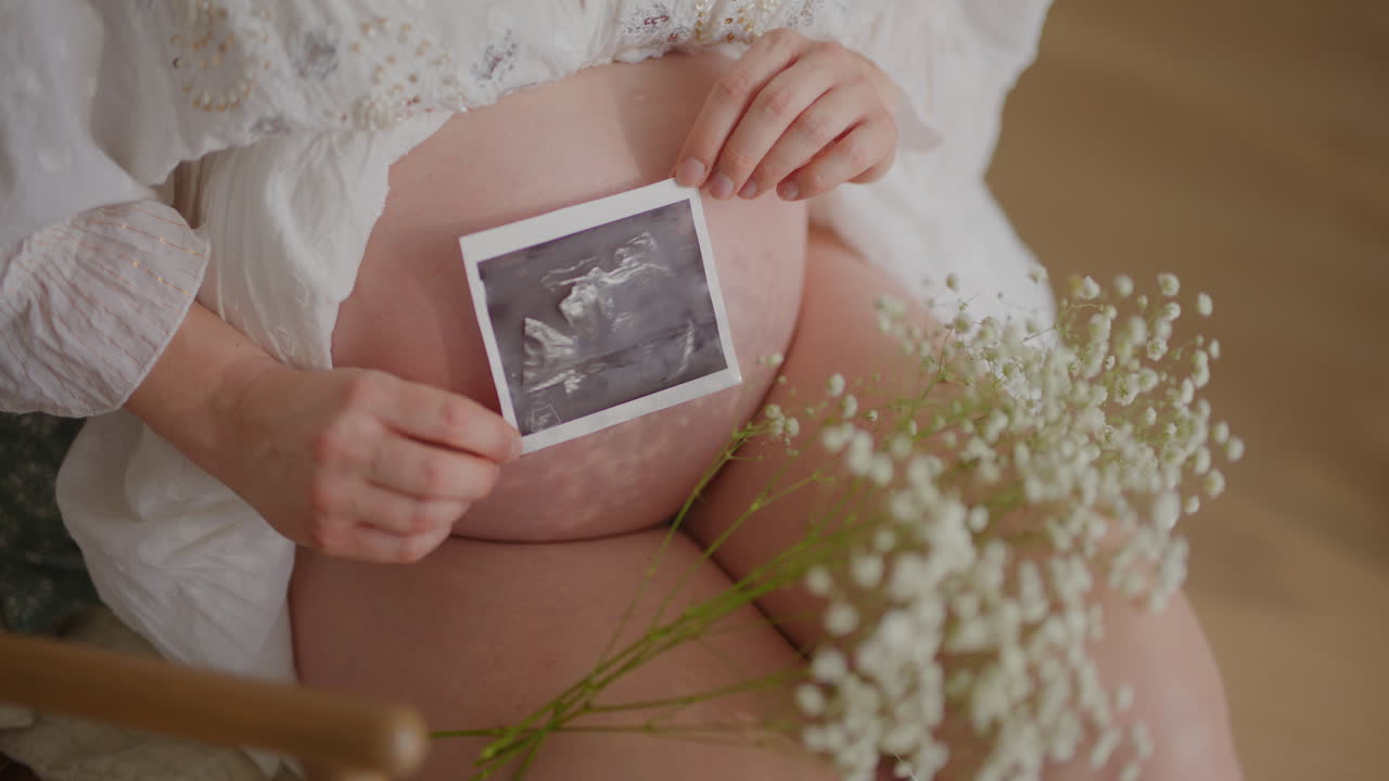 초음파 사진 을 들고 있는 임신 한 여자