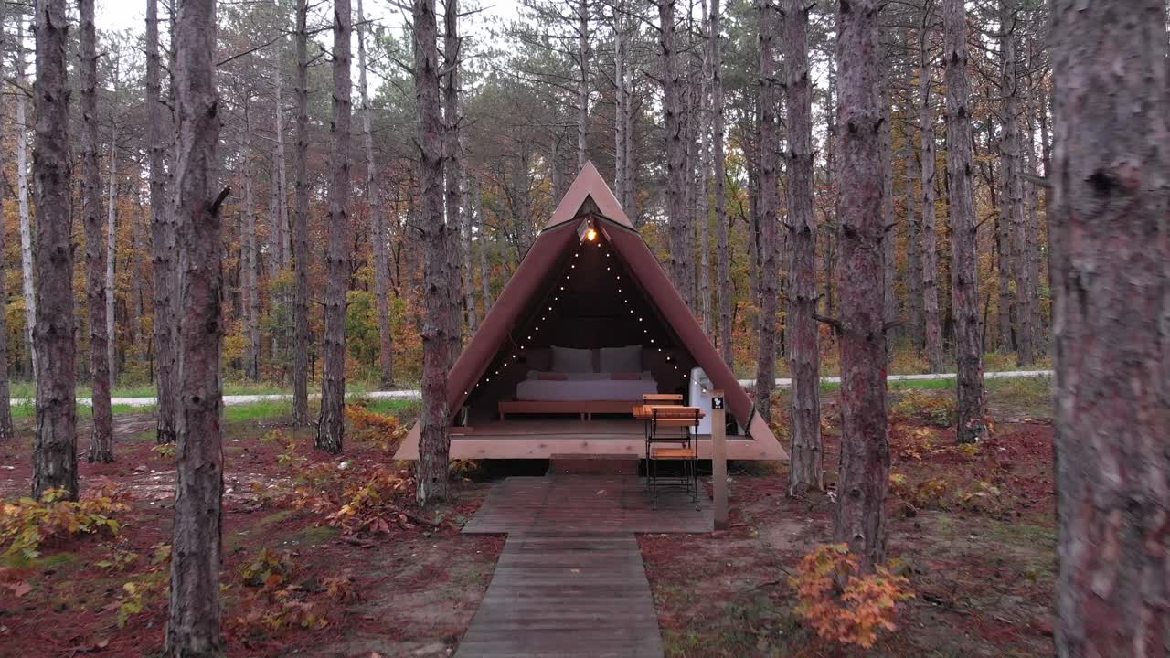 en la temporada de otoño, el dron conduce hacia la casa triangular y se eleva hacia el bosque